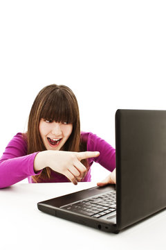 Surprised girl with laptop. Pointing at it