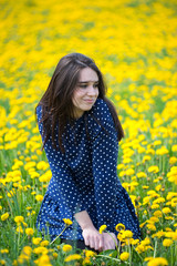 Naklejka na ściany i meble Girl enjoying her free time on a field of yellow flowers
