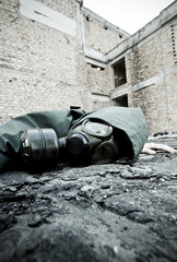 Man with gas mask fallen on the ground