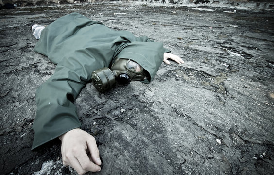 Man with gas mask fallen on the ground