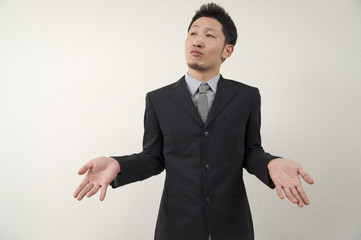 やれやれという表情をするスーツ姿の日本人