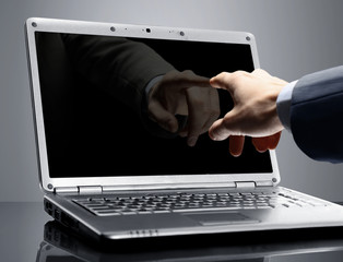 Close-up of male hand with forefinger pointing at laptop