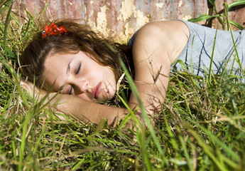 Beautiful teenage girl sleeping in a field