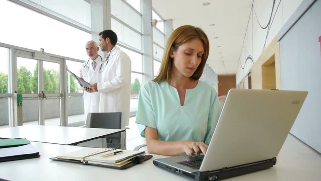 Nurse working on laptop computer in hospital