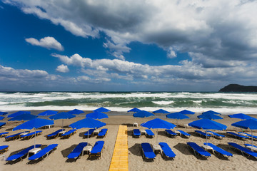 Blue parasols at an empty, stormy beach