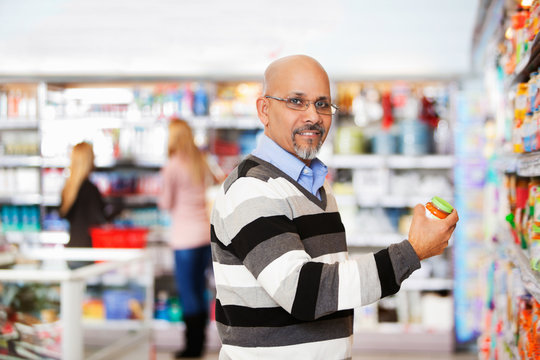 Smiling mature man shopping in the supermarket