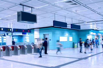 Walking people in subway station, blue toned.