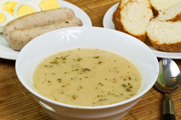 Traditional white borsch soup with eggs and sausages