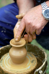 hands of a potter, creating an earthen jar on the circle