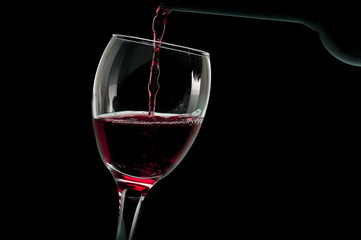 Glass of red wine with bottle