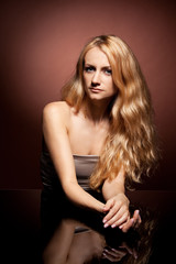 Naklejka premium Fashion portrait of sensual young woman on brown background