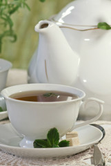 Teapot and cup of tea with mint