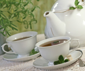 Teapot and cup of tea with mint