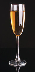 Glass with champagne on black background