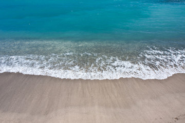 vague bleue et sable blanc aux Seychelles