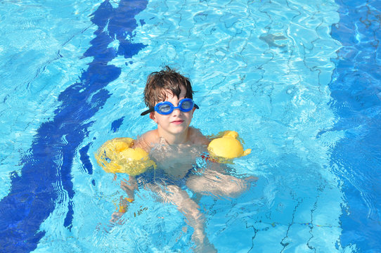Boy in goggles in the swimming pool