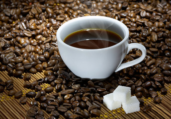 Coffee cup with sugar on roasted beans