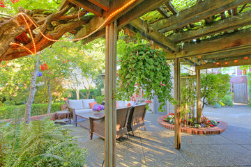 Fototapeta na wymiar Covered deck with cozy sitting area with lots of green