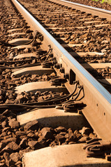 Close up shot of a rusty rails with wires attached to them