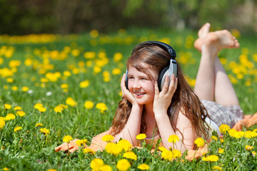 mädchen hört musik auf blumenwiese