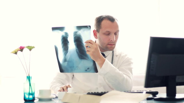 Male doctor looking at xray of human lungs