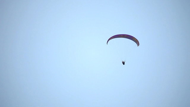 Paraglider glide and down against the sky