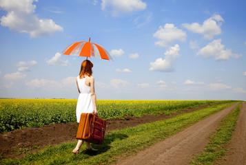 Redhead enchantress walking near rapeseed field.
