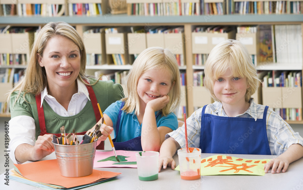 Wall mural Kindergarten teacher sitting with students in art class