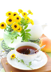 Still life with tea and yellow flowers