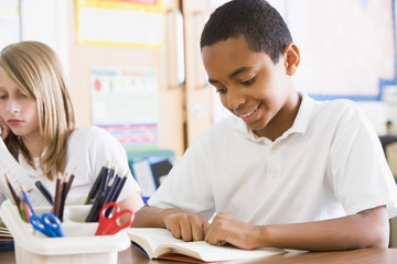 Obraz premium Schoolchildren reading books in class