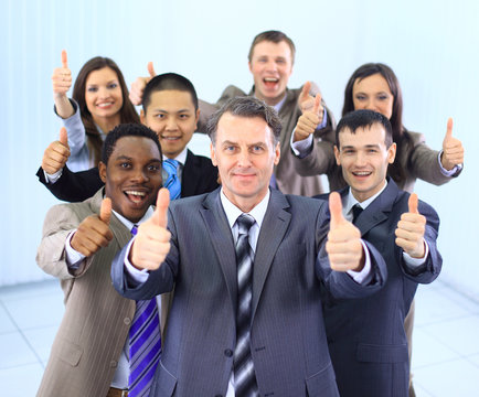 Happy multi-ethnic business team with thumbs up in the