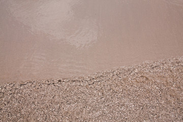 Ripple water to the sand beach background texture