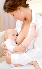 Obraz na płótnie Canvas Mother breast feeding her infant