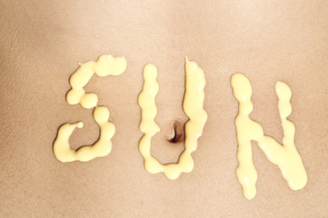 Image of the word sun on the belly of a young girl