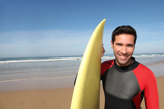 Portrait of young man with surfboard - Powered by Adobe