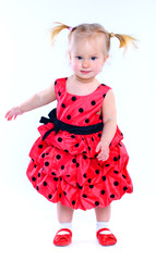 Cute little girl in a red dress. In the studio. Isolated