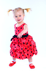 Cute little girl in a red dress. In the studio. Isolated