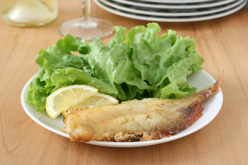 fried red-fish with salad and lemon