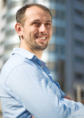 Young smiling man on a background of a modern building