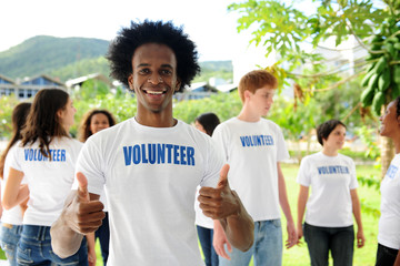 happy volunteer african american man showing thumbs up sign