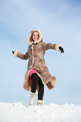 Girl hurries forward on snow in winter and swings arms