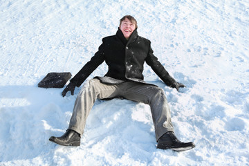 Fototapeta na wymiar Student sits on snow and makes merry