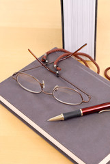 Fototapeta premium Reading Glasses and Pen on Book