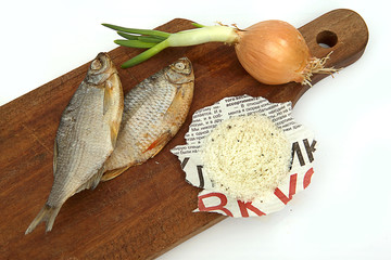 Dried fish, onions and salt on a board