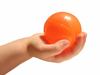 Two year olds hand  holding an orange ball
