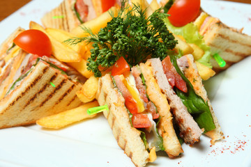 Close-up of sandwich with ham and fried potatoes on a plate