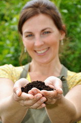 Junge Frau mit Blumenerde