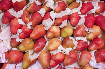 Red pears in wrapping paper on farmers fruit stand