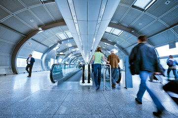 blurred passengers on indoor moving walkway