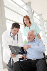 Medical team checking X-ray with patient